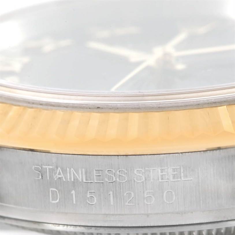 The image shows a close-up of the side of a Rolex Datejust 116233 Men
s Stainless Steel Black Dial 116233 Men
s Stainless Steel Black Dial watch, displaying the fluted bezel and part of the stainless steel casing with engraving.