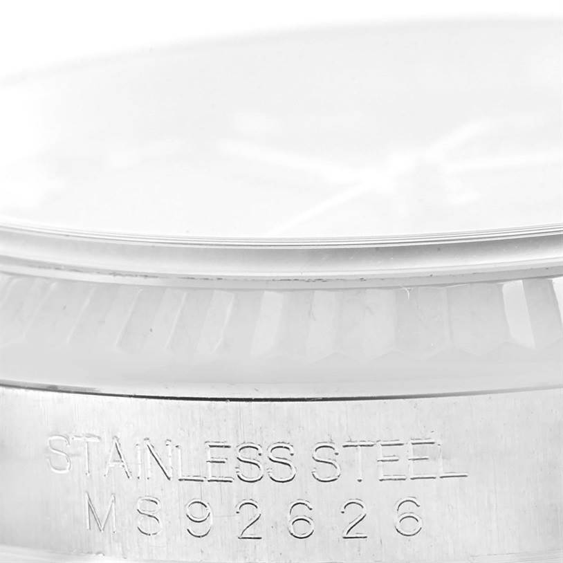 This close-up of the Rolex Datejust 116234 Men
s Stainless Steel Black Dial 116234 Men
s Stainless Steel Black Dial watch shows the edge of the crystal, the fluted bezel, and part of the stainless steel case with the serial number.