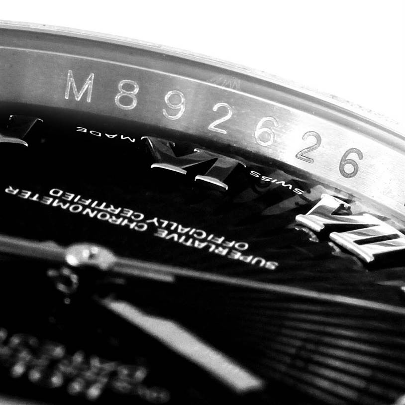 The image shows a close-up of the serial number and part of the dial of a Rolex Datejust 116234 Men
s Stainless Steel Black Dial 116234 Men
s Stainless Steel Black Dial watch.