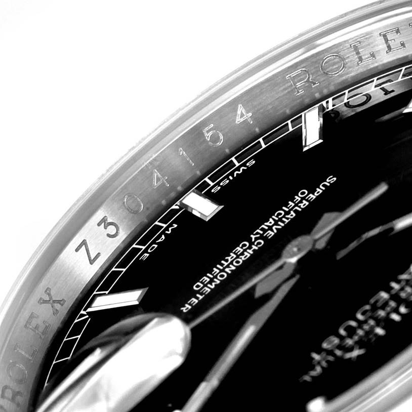 The image shows a close-up angle of the Rolex Datejust 116200 Men
s Stainless Steel Black Dial 116200 Men
s Stainless Steel Black Dial model highlighting the watch bezel, part of the dial, hands, and engraving.