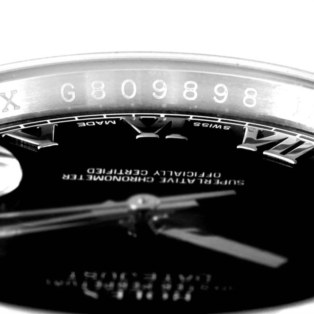 The image shows a close-up of the dial, hands, and part of the inscription on the inner flange of a Rolex Datejust 116200 Men
s Stainless Steel Black Dial 116200 Men
s Stainless Steel Black Dial watch.