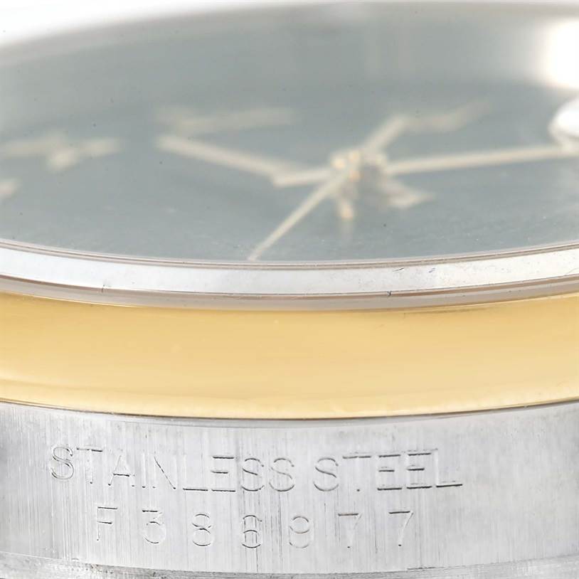 This angled shot shows the side of the Rolex Datejust 116203 Men's Stainless Steel Black Dial 116203 Men's Stainless Steel Black Dial watch, highlighting the "STAINLESS STEEL" inscription and serial number.