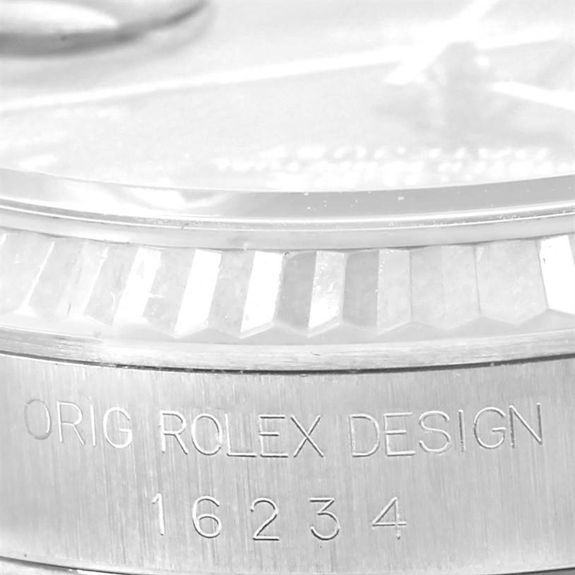 The image shows a close-up of the bezel and case of the Rolex Datejust 16234 Men's Stainless Steel Blue Dial 16234 Men's Stainless Steel Blue Dial model, including an engraved design and model number.