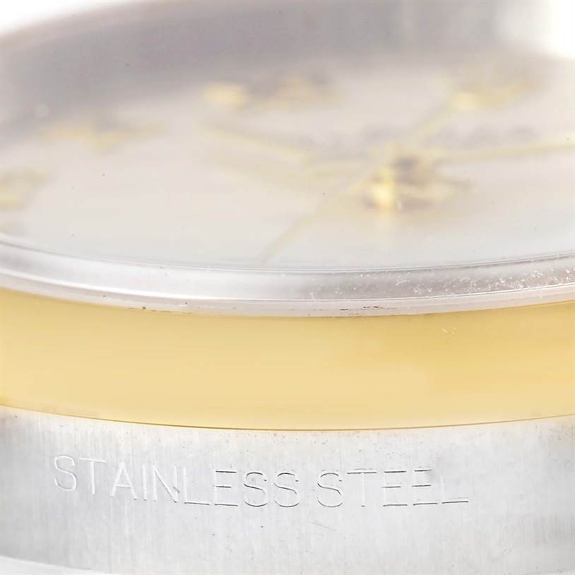 This close-up of the Rolex Datejust 116203 Men's Stainless Steel Beige Dial 116203 Men's Stainless Steel Beige Dial watch shows the side view of the case, with "Stainless Steel" engraved on it.