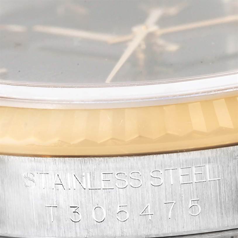 The image shows a close-up of the side of a Rolex Datejust 16233 Men's Steel and Gold (two tone) Black Dial 16233 Men's Steel and Gold (two tone) Black Dial watch, focusing on the stainless steel case and serial number.