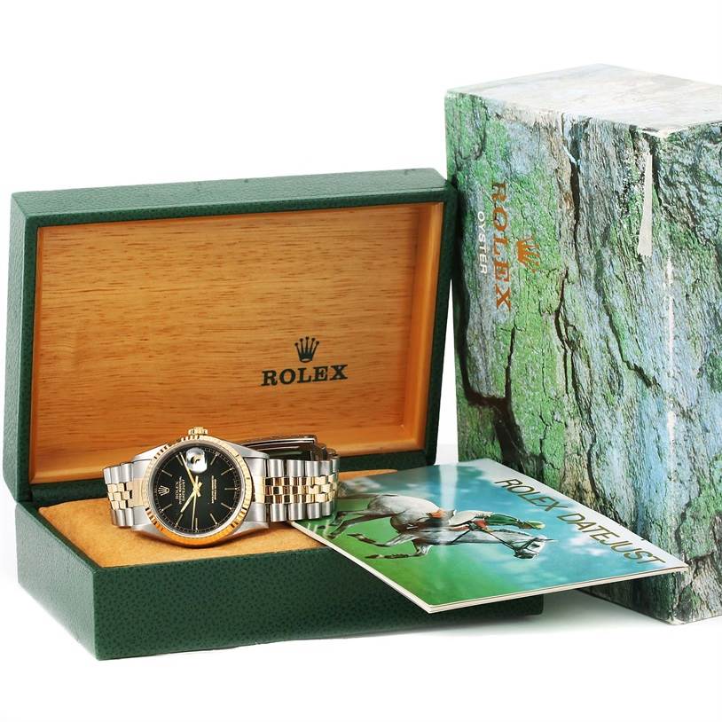 The Rolex Datejust 16233 Men's Steel and Gold (two tone) Black Dial 16233 Men's Steel and Gold (two tone) Black Dial watch is shown in its box alongside its booklet and outer packaging from a front angle.