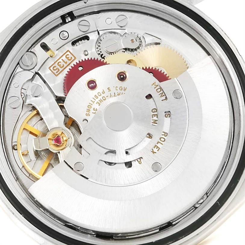The image shows the internal mechanism of a Rolex Datejust 16233 Men's Steel and Gold (two tone) Black Dial 16233 Men's Steel and Gold (two tone) Black Dial watch, revealing gears, springs, and the rotor.