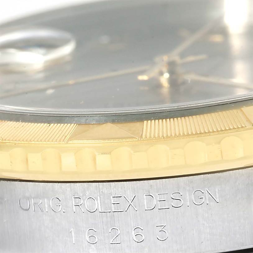 The image shows a close-up side angle of a Rolex Datejust 16263 Men's Steel and Gold (two tone) Grey Dial 16263 Men's Steel and Gold (two tone) Grey Dial, highlighting the bezel, the crystal, and part of the watch's case with the engraving "16263".