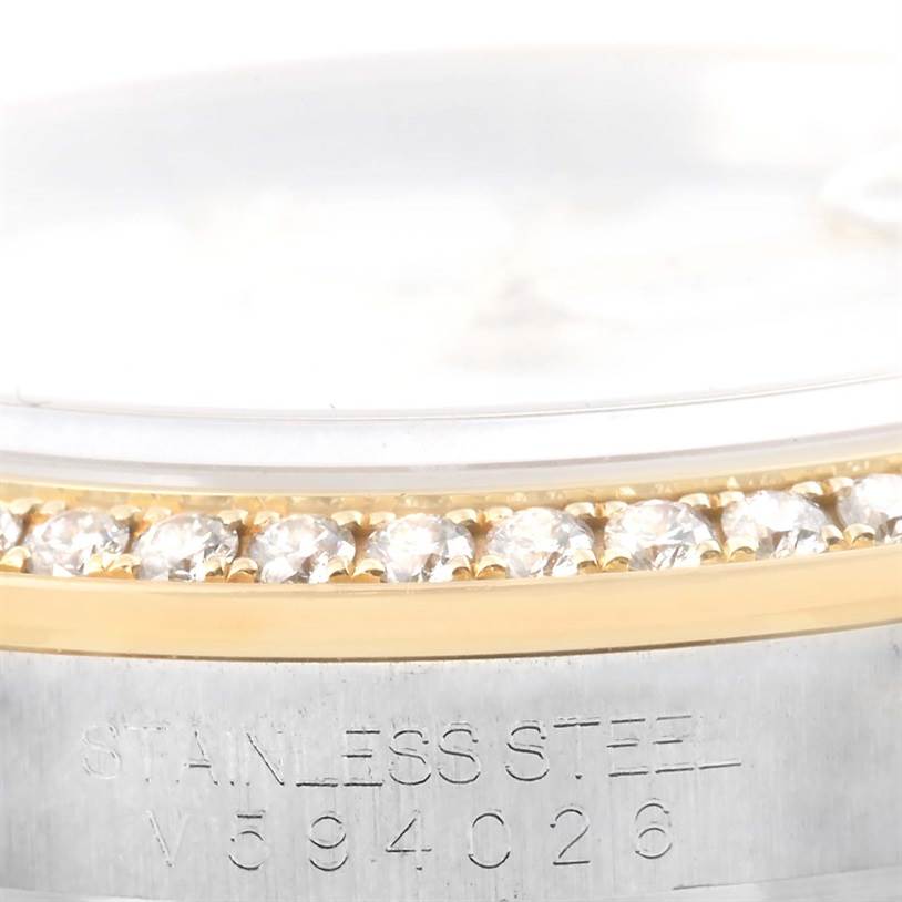This close-up image of a Rolex Datejust 116243 Stainless Steel White Dial 116243 Stainless Steel White Dial model shows the bezel with diamonds, part of the dial, and the stainless steel casing with engraving.