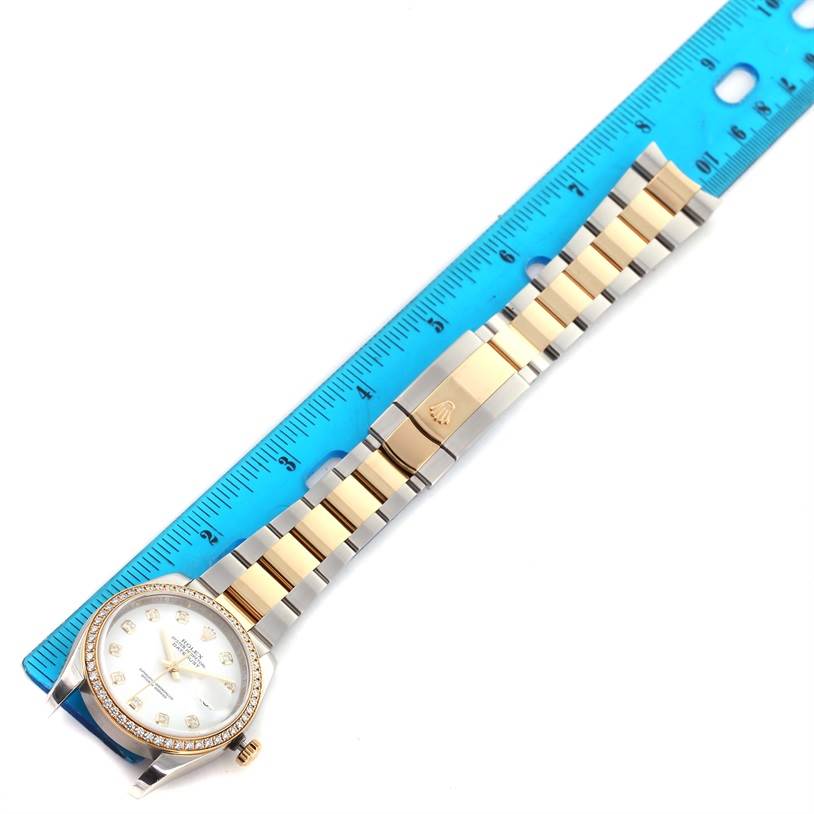 This image shows a Rolex Datejust 116243 Stainless Steel White Dial 116243 Stainless Steel White Dial watch laid flat with a ruler beside it, displaying its full band and face.