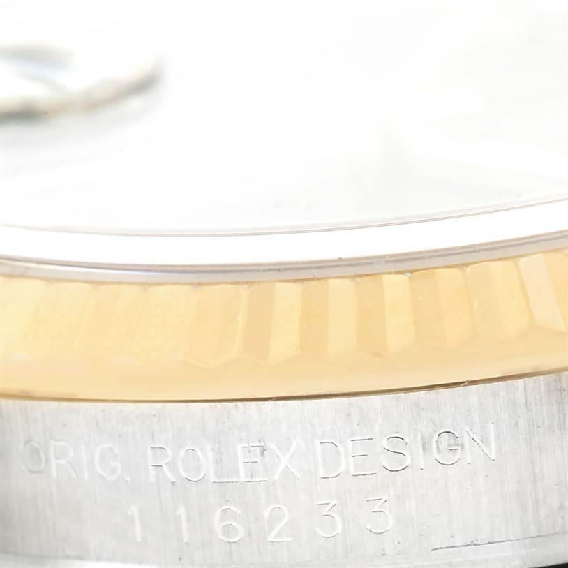 This is a close-up side view of a Rolex Datejust 116233 Men
s Stainless Steel Black Dial 116233 Men
s Stainless Steel Black Dial model, showing the fluted bezel and engraved design information.