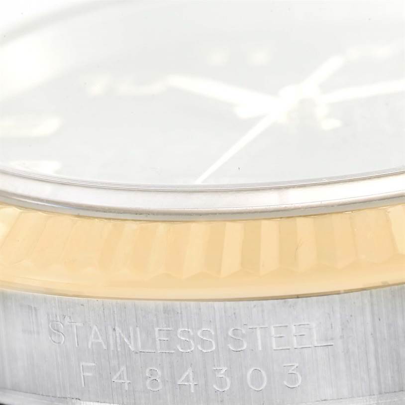 The image shows a close-up angle of the Rolex Datejust 116233 Men
s Stainless Steel Black Dial 116233 Men
s Stainless Steel Black Dial watch, focusing on the fluted bezel, crystal, and the etched "STAINLESS STEEL" text.