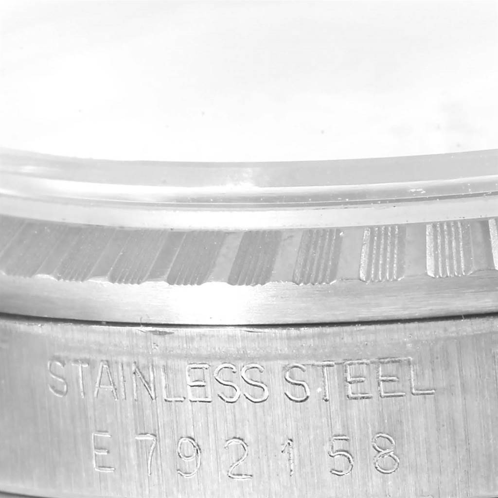 This close-up angle of the Rolex Datejust 16220 Men
s Stainless Steel Silver Dial 16220 Men
s Stainless Steel Silver Dial watch shows the bezel and part of the case with the "STAINLESS STEEL" engraving and serial number.