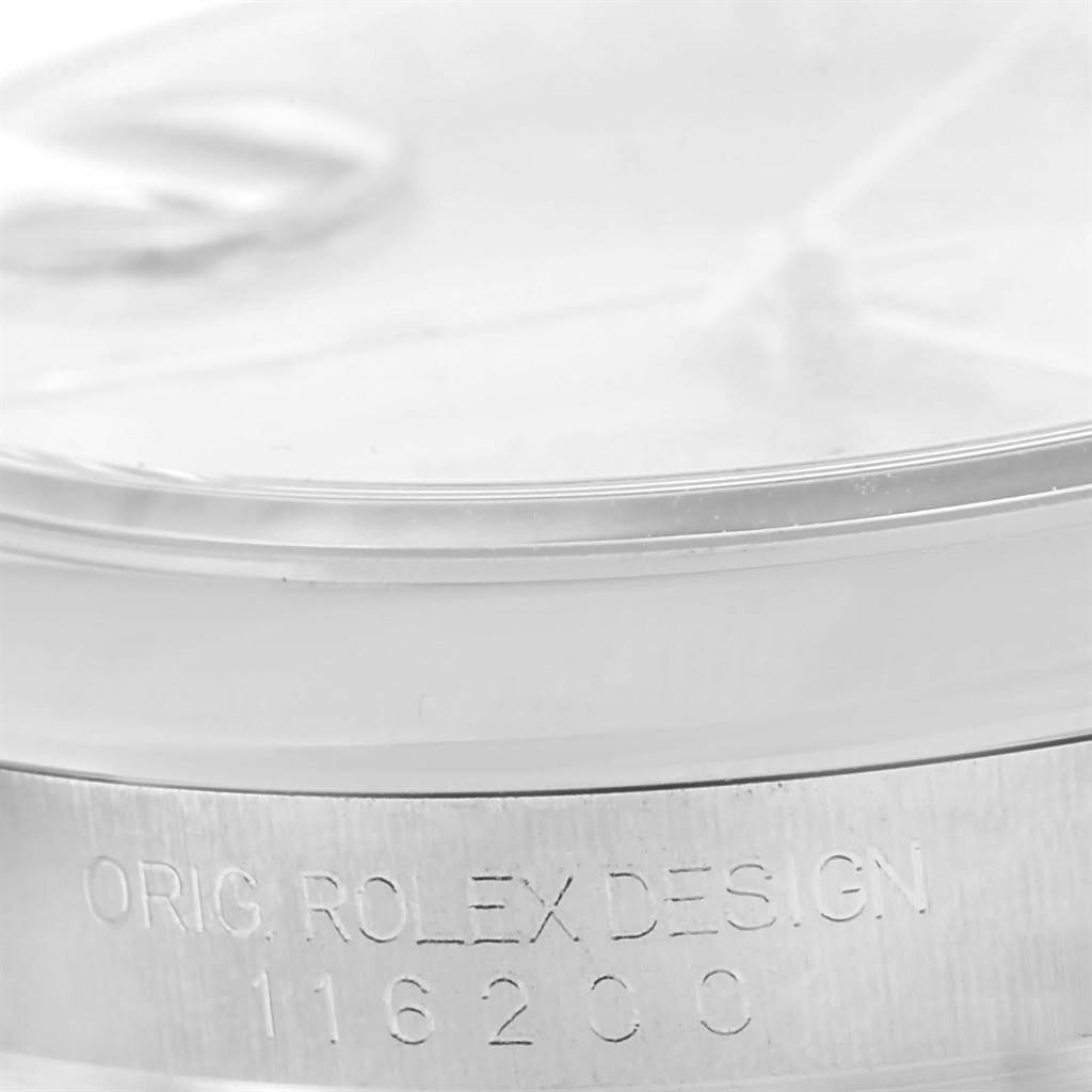 The image shows a close-up angle of the side of the Rolex Datejust 116200 Men
s Stainless Steel Silver Dial 116200 Men
s Stainless Steel Silver Dial watch case, revealing the engraved model number and "ORIG ROLEX DESIGN".