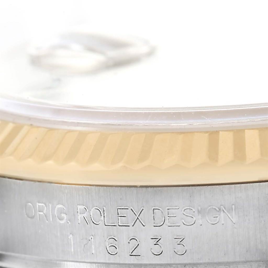 This image shows a close-up of the side of a Rolex Datejust 116233 Men's Stainless Steel Black Dial 116233 Men's Stainless Steel Black Dial watch, highlighting the fluted bezel and part of the watch case.