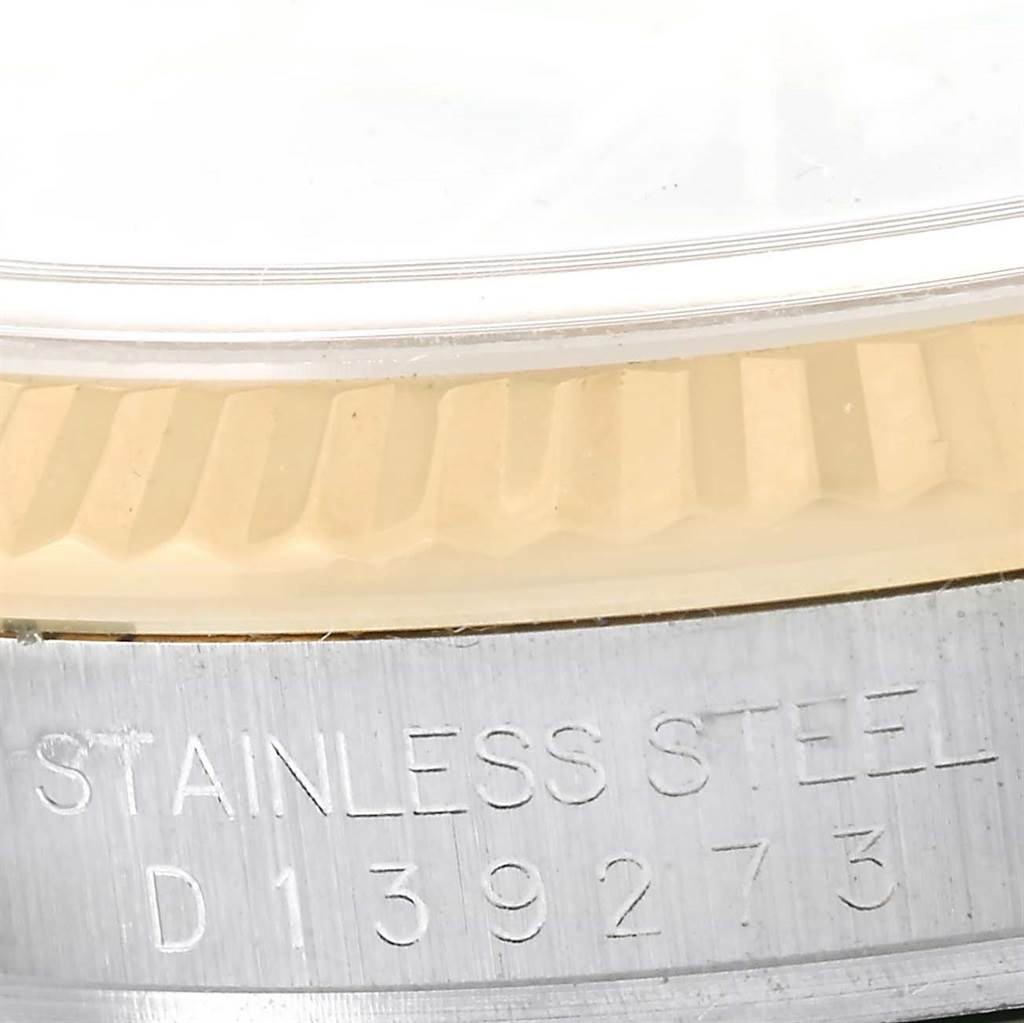 The image shows a close-up of the fluted bezel and part of the stainless steel case of a Rolex Datejust 116233 Men's Stainless Steel Black Dial 116233 Men's Stainless Steel Black Dial watch.