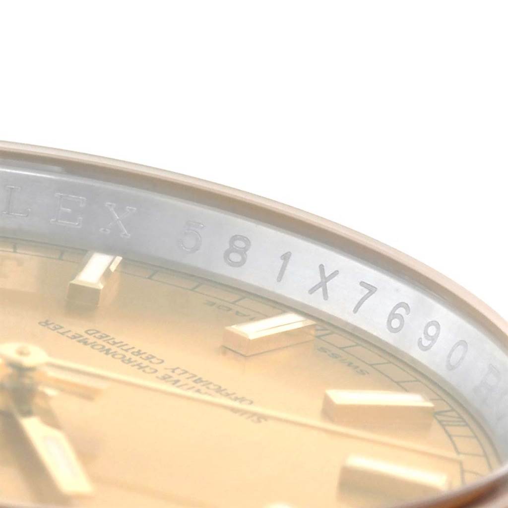 This close-up angle shows the dial and inner bezel of the Rolex Datejust 116233 Men's Stainless Steel Champagne Dial 116233 Men's Stainless Steel Champagne Dial watch, featuring engraved numbers and part of the brand name.