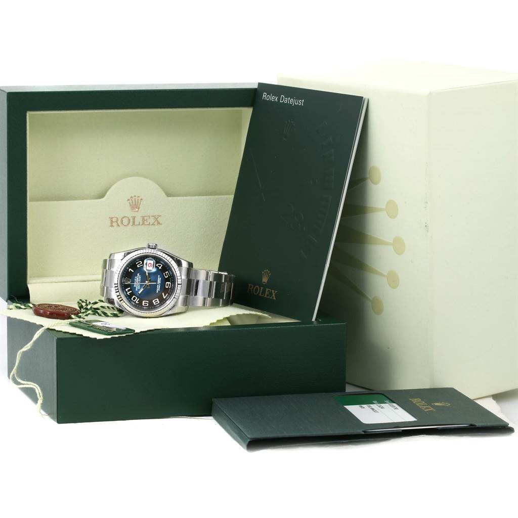 The Rolex Datejust 116234 Men
s Stainless Steel Blue Dial 116234 Men
s Stainless Steel Blue Dial watch is displayed in its open box, with accompanying booklets and accessories shown.