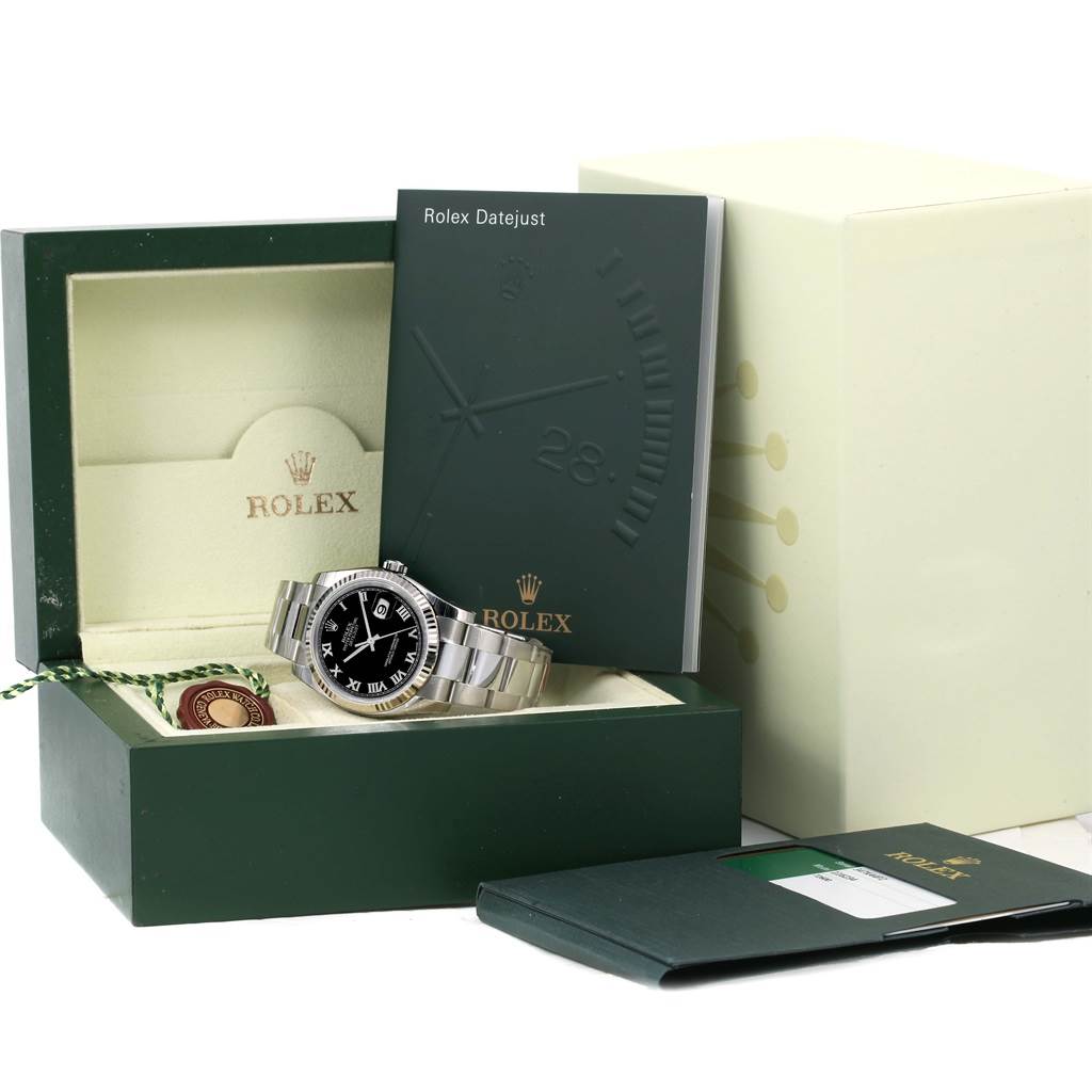 The image shows a Rolex Datejust 116234 Men's Stainless Steel Black Dial 116234 Men's Stainless Steel Black Dial watch in its open box with instruction booklets and tags arranged beside and inside the box.