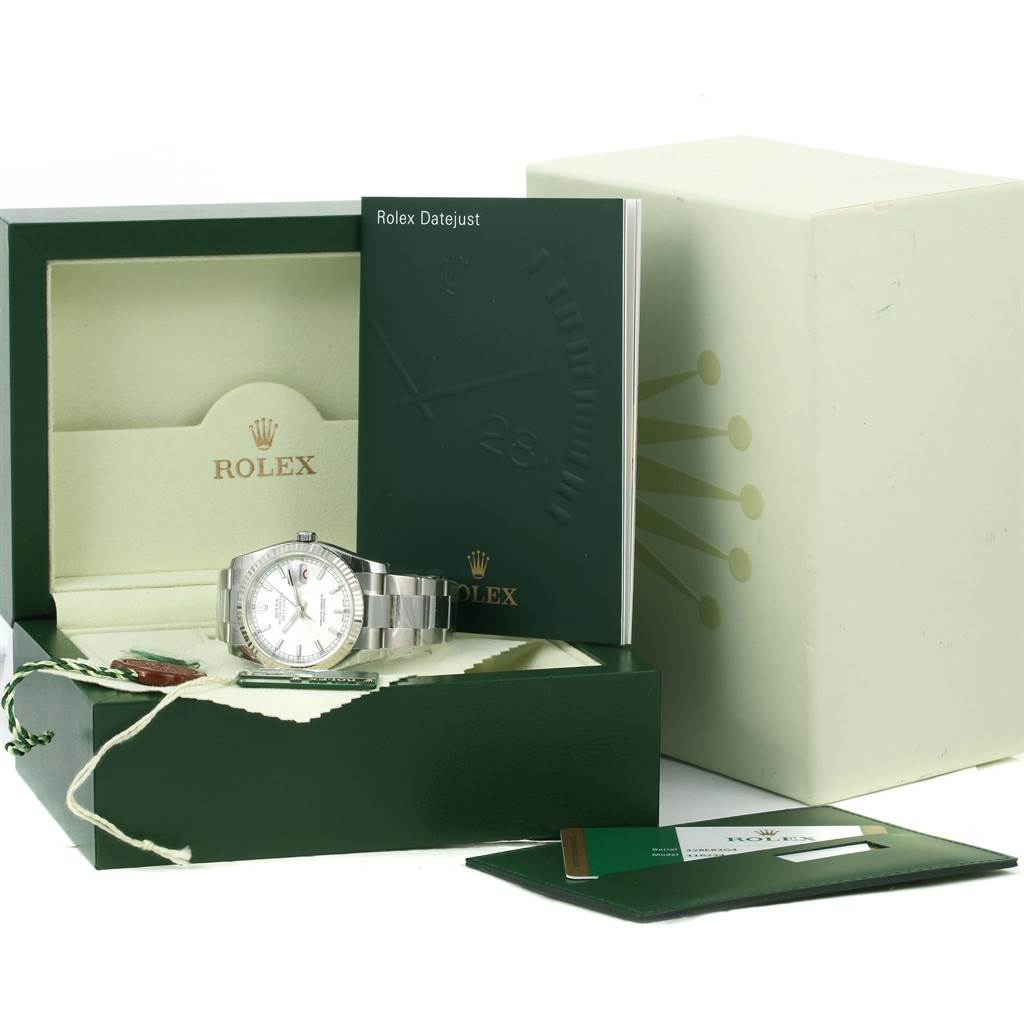 The image shows a Rolex Datejust 116234 Men
s Stainless Steel White Dial 116234 Men
s Stainless Steel White Dial watch from a front angle in an open box, accompanied by booklets and tags.