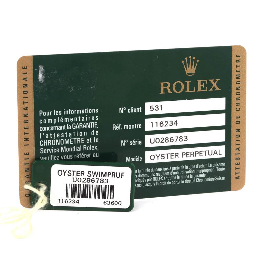 The image shows the warranty card for a Rolex Datejust 116234 Men
s Stainless Steel Silver Dial 116234 Men
s Stainless Steel Silver Dial model and an attached tag with serial number and information.