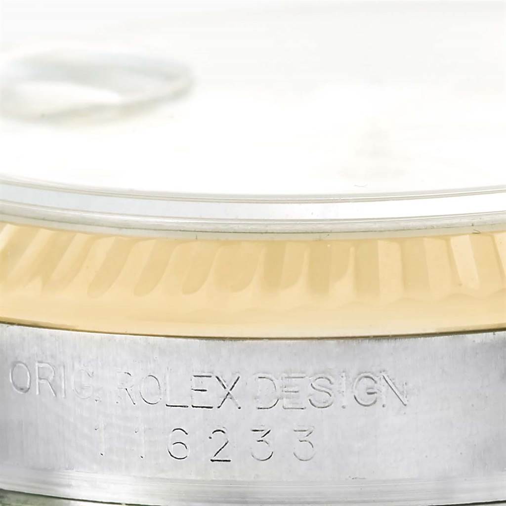This image shows a close-up of the Rolex Datejust 116233 Men's Stainless Steel White Dial 116233 Men's Stainless Steel White Dial model's bezel and case with the engraving "ORIG. ROLEX DESIGN 116233".