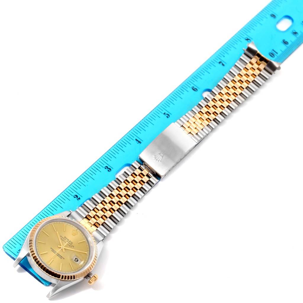 The image displays a Rolex Datejust 16233 Men's Steel and Gold (two tone) Champagne Dial 16233 Men's Steel and Gold (two tone) Champagne Dial watch laid flat, with a measuring ruler beside it, showing the full bracelet and face.