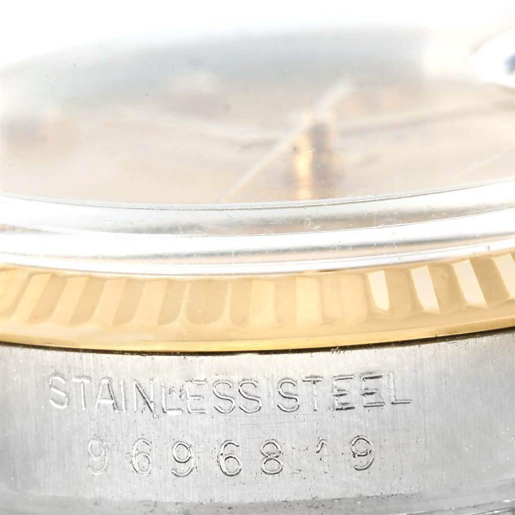 The image shows a close-up of the side of a Rolex Datejust 16013 Stainless Steel Champagne Dial 16013 Stainless Steel Champagne Dial watch, highlighting the fluted bezel and "STAINLESS STEEL" engraving.