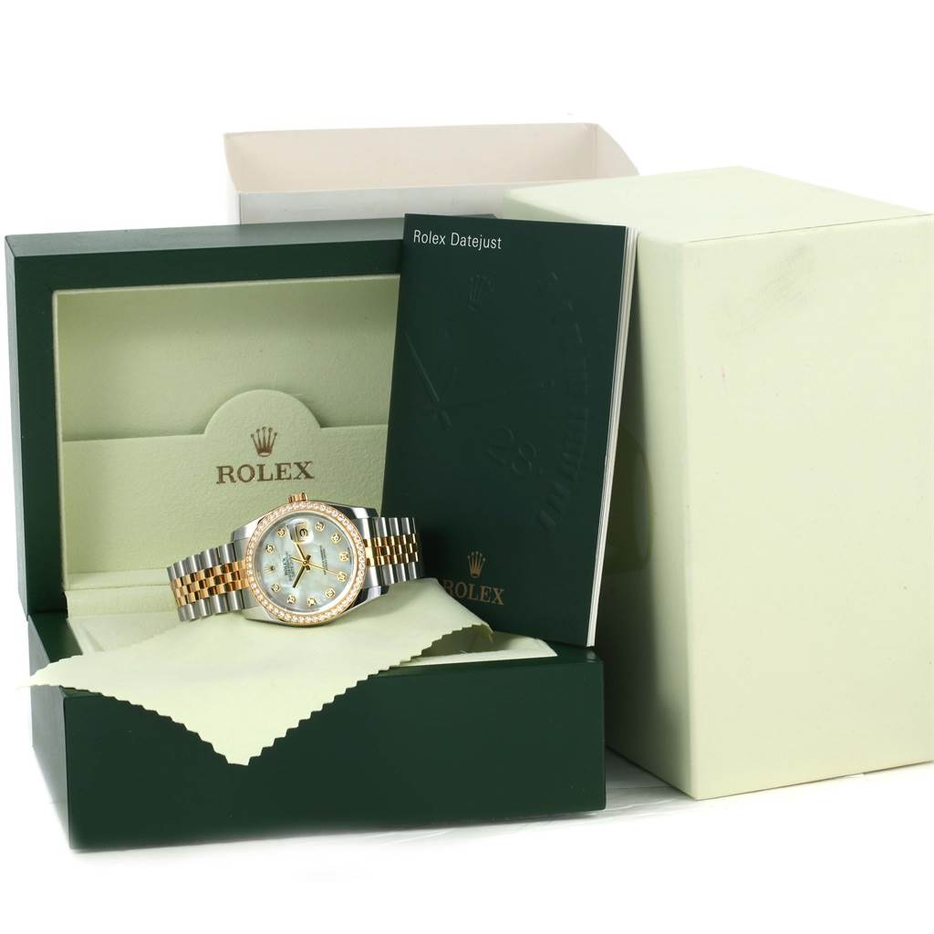 The Rolex Datejust 116243 Men's Stainless Steel Mother of Pearl Dial 116243 Men's Stainless Steel Mother of Pearl Dial watch is shown front-facing in an open box, accompanied by a booklet and cleaning cloth.