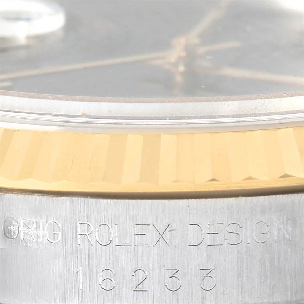 This close-up angle of the Rolex Datejust 16233 Men's Steel and Gold (two tone) Black Dial 16233 Men's Steel and Gold (two tone) Black Dial watch shows the bezel, part of the crystal, and the model and brand engraving.