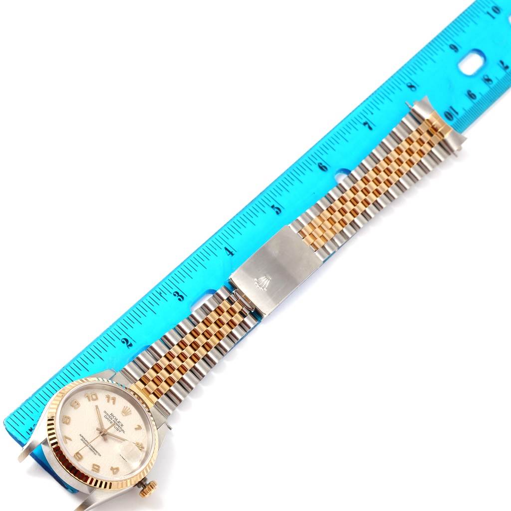 This image shows a Rolex Datejust 16233 Men's Steel and Gold (two tone) Beige Dial 16233 Men's Steel and Gold (two tone) Beige Dial watch laid flat beside a ruler, displaying the dial, bracelet, and clasp.