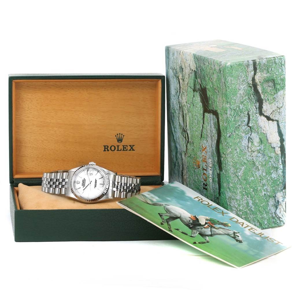 The image shows a Rolex Datejust 16234 Men
s Stainless Steel White Dial 16234 Men
s Stainless Steel White Dial watch inside its open box and the outer packaging with a manual.