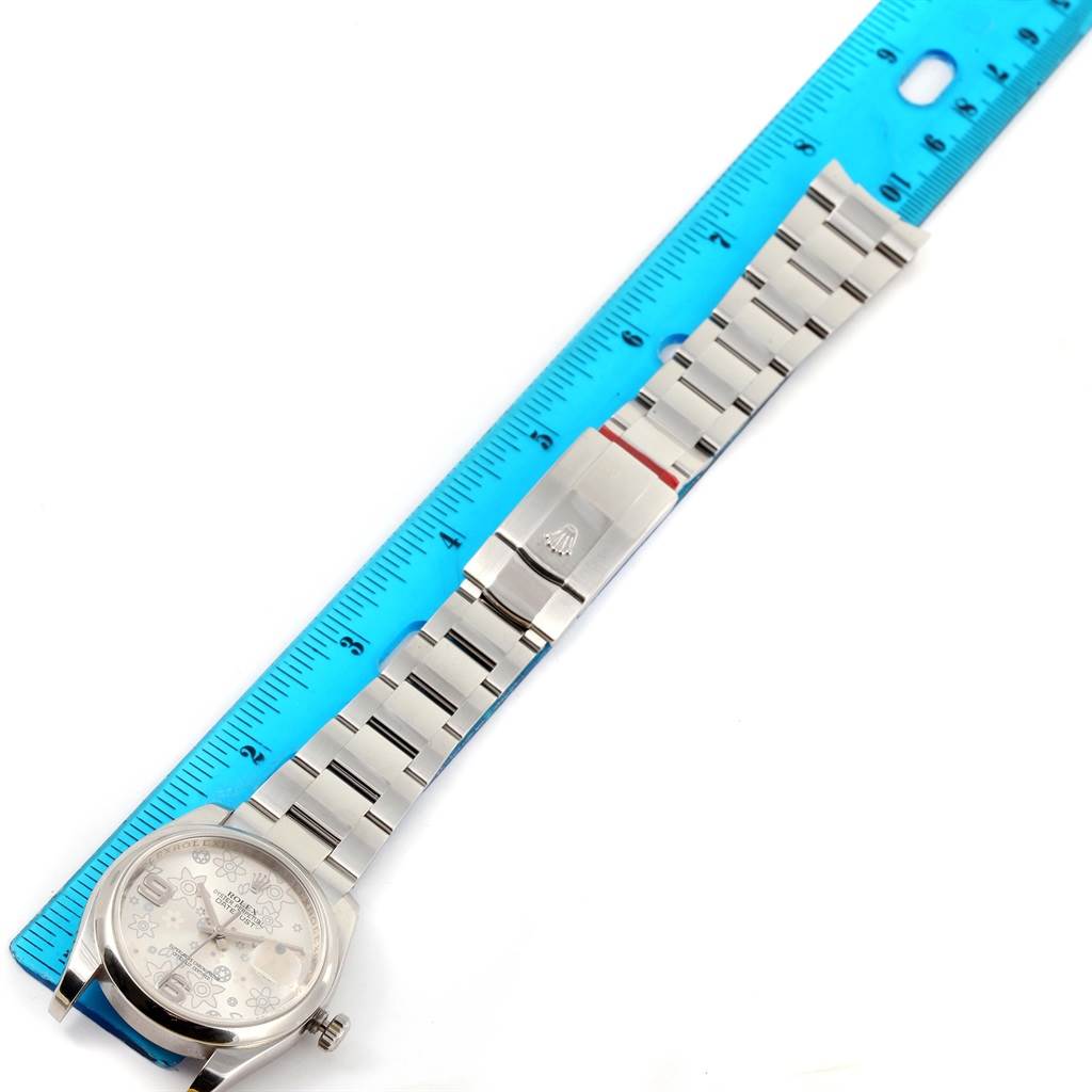 The Rolex Datejust 116200 Men
s Stainless Steel Silver Dial 116200 Men
s Stainless Steel Silver Dial watch is shown flat with the face and bracelet visible, alongside a blue ruler for scale.