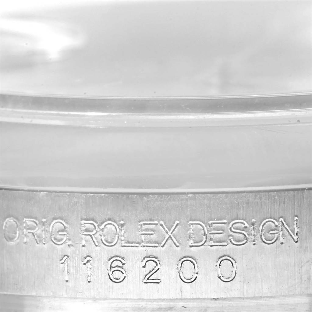 The image shows a close-up of the side engraving on a Rolex Datejust 116200 Men
s Stainless Steel Silver Dial 116200 Men
s Stainless Steel Silver Dial watch, displaying "ORIG. ROLEX DESIGN 116200."