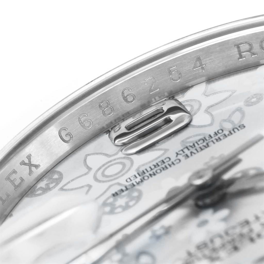 This close-up image of the Rolex Datejust 116200 Men
s Stainless Steel Silver Dial 116200 Men
s Stainless Steel Silver Dial model shows the engraved serial number and part of the dial and hands.