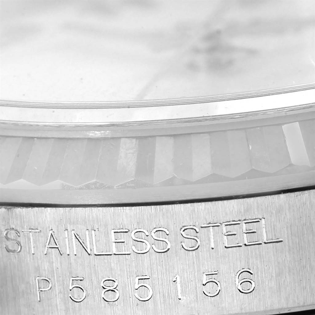 This close-up image of the Rolex Datejust 16234 Men's Stainless Steel Silver Dial 16234 Men's Stainless Steel Silver Dial watch focuses on the serial number and part of the stainless steel casing.