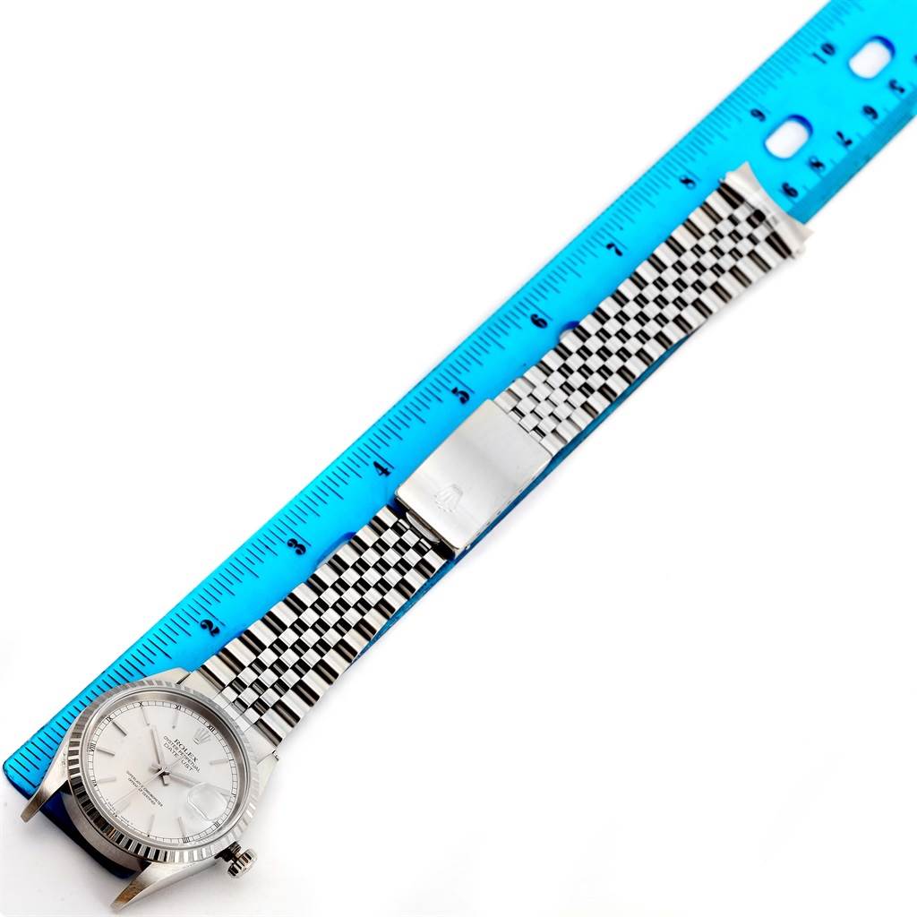 The Rolex Datejust 16220 Men's Stainless Steel Silver Dial 16220 Men's Stainless Steel Silver Dial watch is shown from a top angle, highlighting the face, bracelet, and clasp, with a ruler for scale.