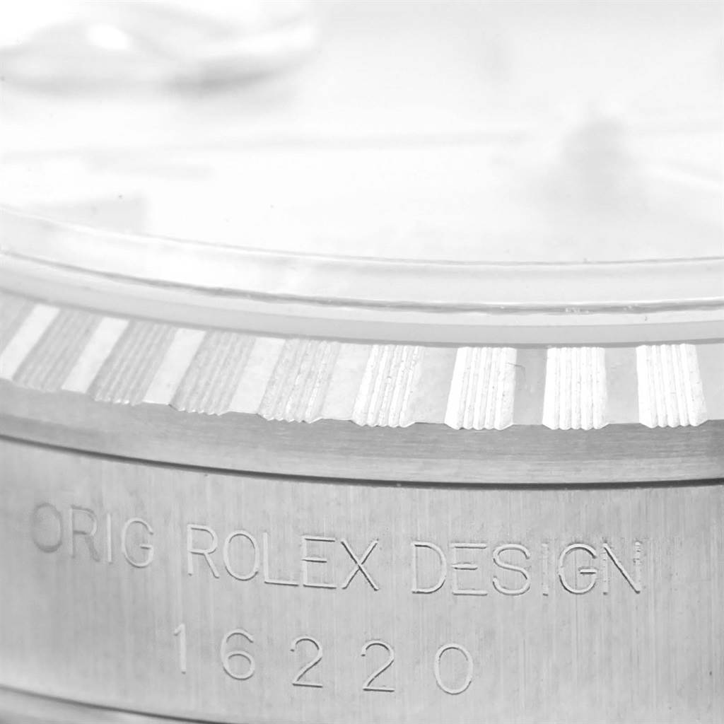This image shows a close-up of the bezel and serial number engraving on a Rolex Datejust 16220 Men's Stainless Steel Silver Dial 16220 Men's Stainless Steel Silver Dial watch.