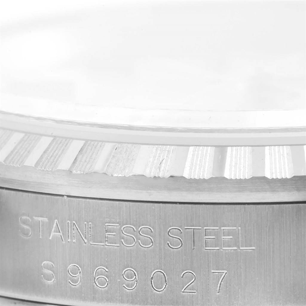 This is a close-up image of the stainless steel casing and bezel of a Rolex Datejust 16220 Men's Stainless Steel Silver Dial 16220 Men's Stainless Steel Silver Dial watch, showing engravings and the serial number.