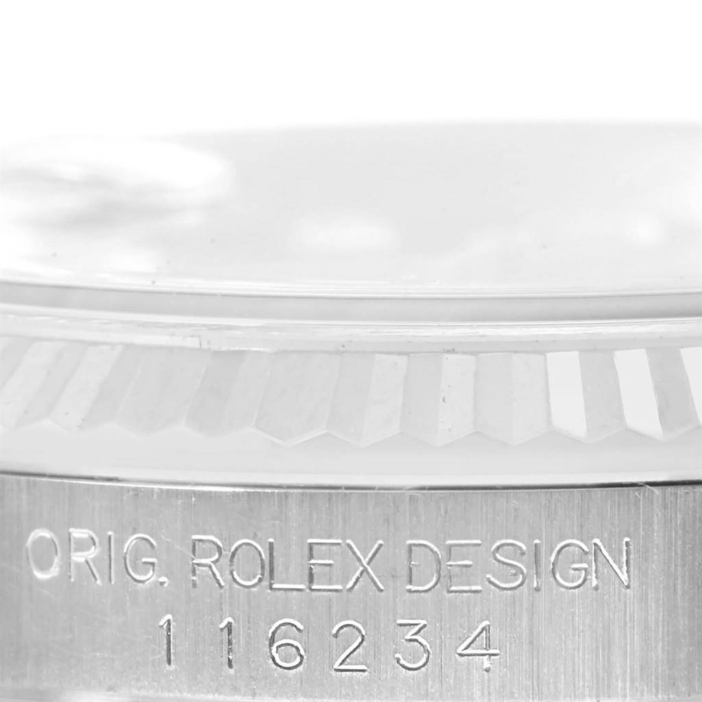 The image shows a close-up of the Rolex Datejust 116234 Men
s Stainless Steel Black Dial 116234 Men
s Stainless Steel Black Dial model
s case edge engraved with "ORIG. ROLEX DESIGN 116234".