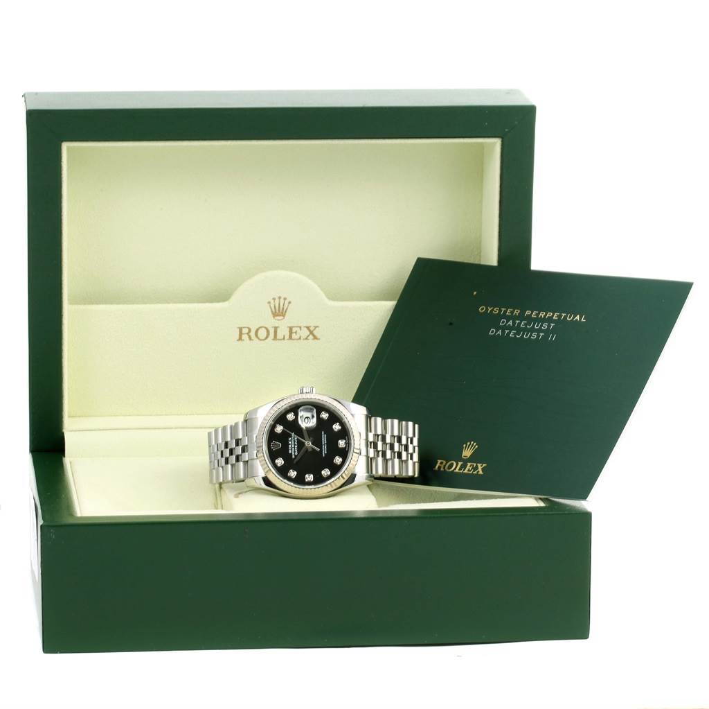 The image shows a Rolex Datejust 116234 Men
s Stainless Steel Black Dial 116234 Men
s Stainless Steel Black Dial watch positioned inside its open green box with accompanying paperwork.