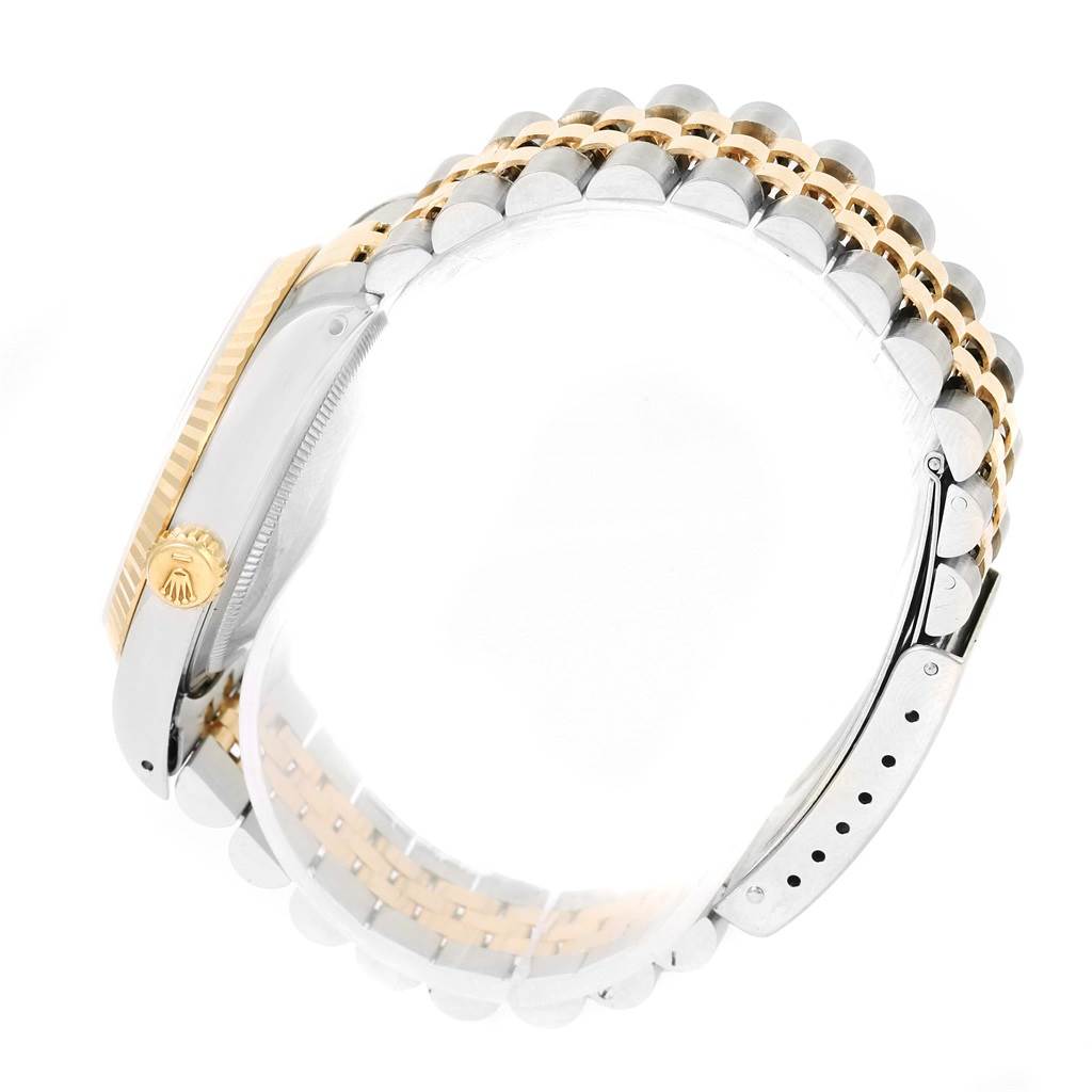 The image shows a side angle of a Rolex Datejust 16233 Men's Steel and Gold (two tone) Black Dial 16233 Men's Steel and Gold (two tone) Black Dial watch highlighting its two-tone bracelet and crown.