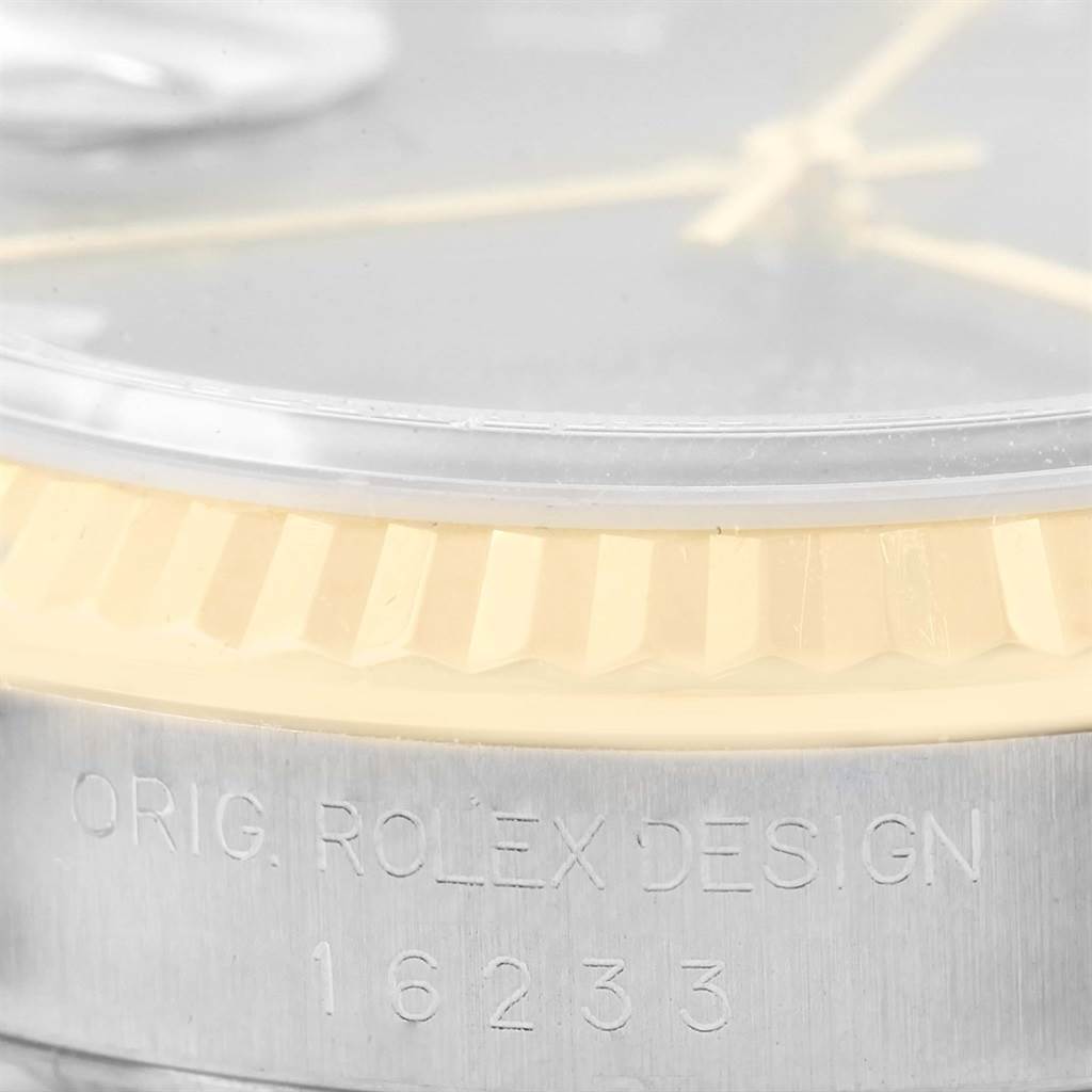 This close-up image shows the bezel, part of the dial, and the engraved case of a Rolex Datejust 16233 Men's Steel and Gold (two tone) Blue Dial 16233 Men's Steel and Gold (two tone) Blue Dial model, with model number 16233.