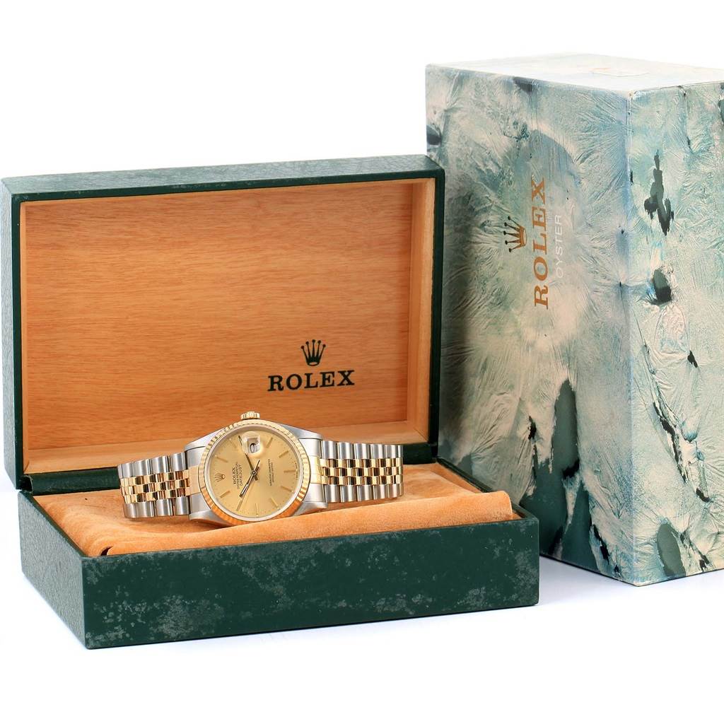 The Rolex Datejust 16233 Men's Steel and Gold (two tone) Champagne Dial 16233 Men's Steel and Gold (two tone) Champagne Dial watch is shown in its opened green and wooden box, with its case and bracelet visible from the front angle.