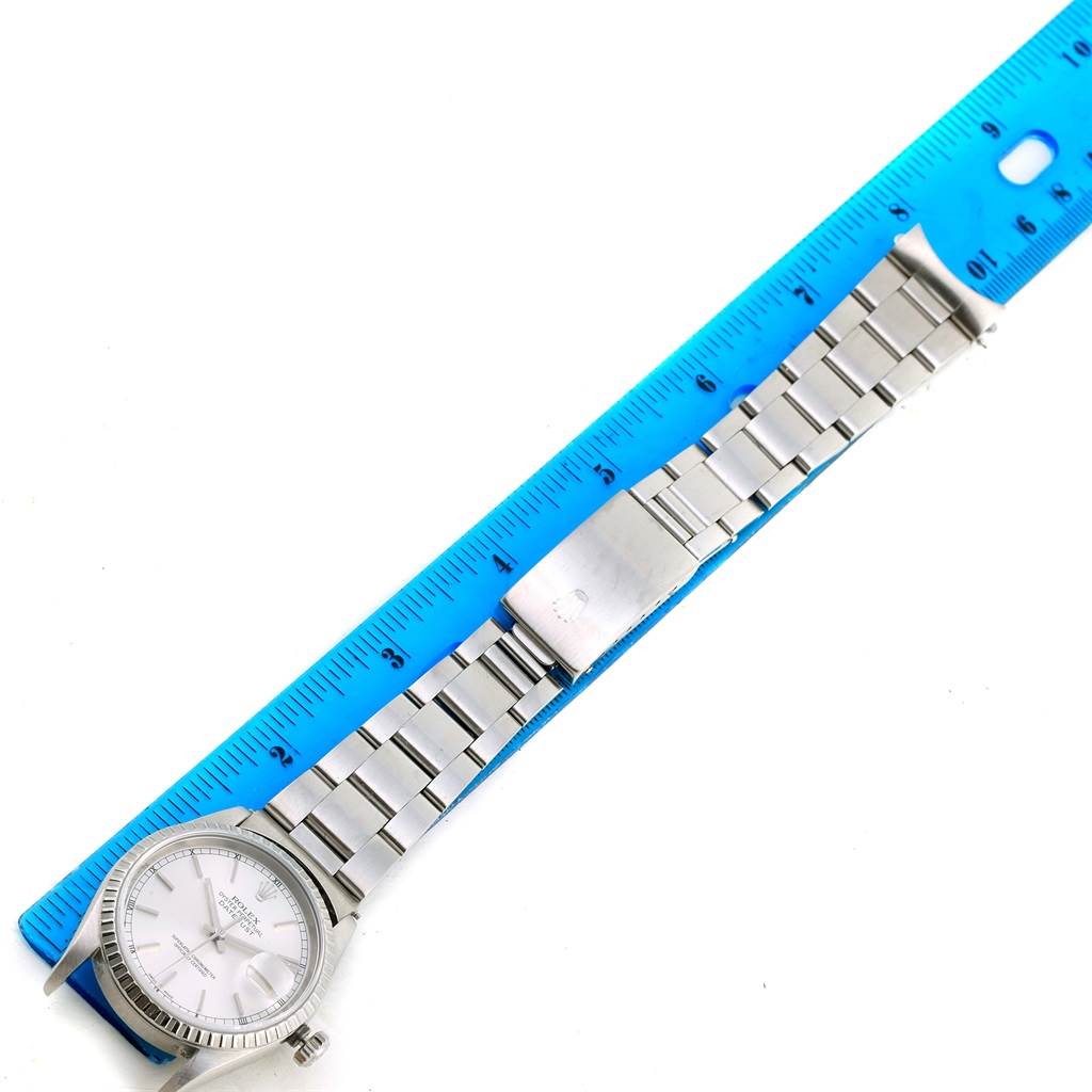 The image shows a Rolex Datejust 16220 Men's Stainless Steel Silver Dial 16220 Men's Stainless Steel Silver Dial watch laid flat next to a blue ruler, highlighting its face and metal bracelet.