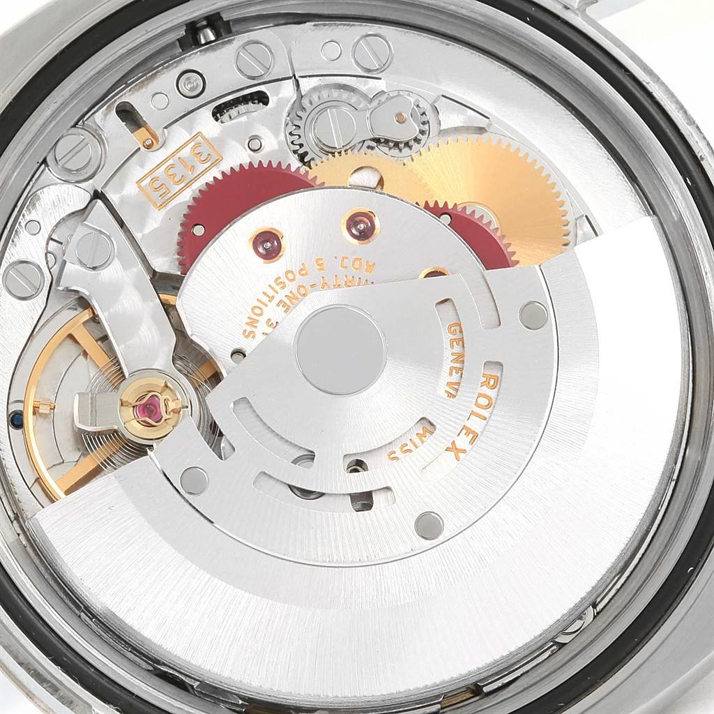 The image shows a close-up of the movement mechanism inside a Rolex Datejust 116234 Men's Stainless Steel Blue Dial 116234 Men's Stainless Steel Blue Dial watch, highlighting gears and the rotor.