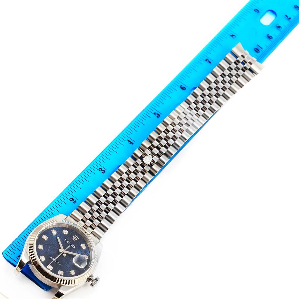The image shows the Rolex Datejust 116234 Men's Stainless Steel Blue Dial 116234 Men's Stainless Steel Blue Dial watch laid flat along a ruler, highlighting its bracelet and face.