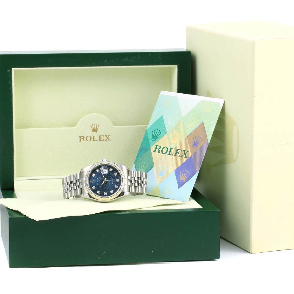 This image shows a Rolex Datejust 116234 Men's Stainless Steel Blue Dial 116234 Men's Stainless Steel Blue Dial watch displayed at an angle inside an open box with a card and cloth beside it.