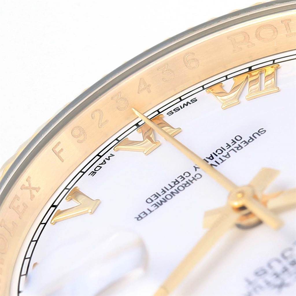 The image shows a close-up of the Rolex Datejust 116138 Men's Yellow Gold White Dial 116138 Men's Yellow Gold White Dial watch's dial, hands, and part of the bezel, highlighting the Roman numerals and branding.
