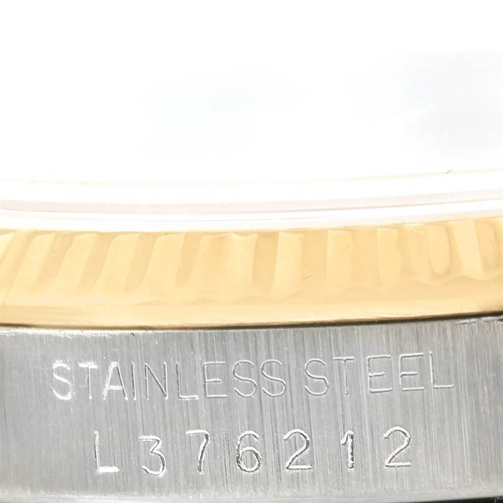 This image shows a close-up of the Rolex Datejust 16233 Men
s Steel and Gold (two tone) Silver Dial 16233 Men
s Steel and Gold (two tone) Silver Dial case, focusing on the bezel and the serial number engraved on the stainless steel part.